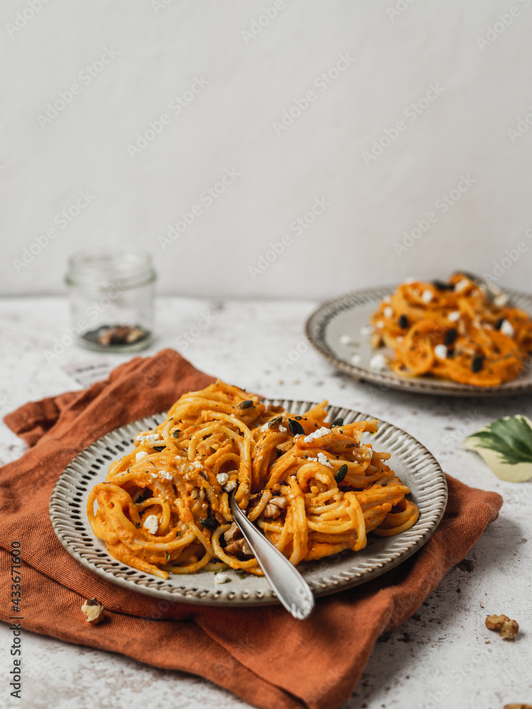 From above of delicious pumpkin noodles with seeds served on plate of table for lunch From above of delicious pumpkin noodles with seeds served on plate of table for lunch