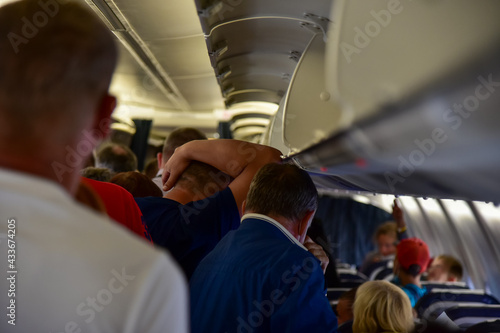 People go to the evacuation exit on the plane