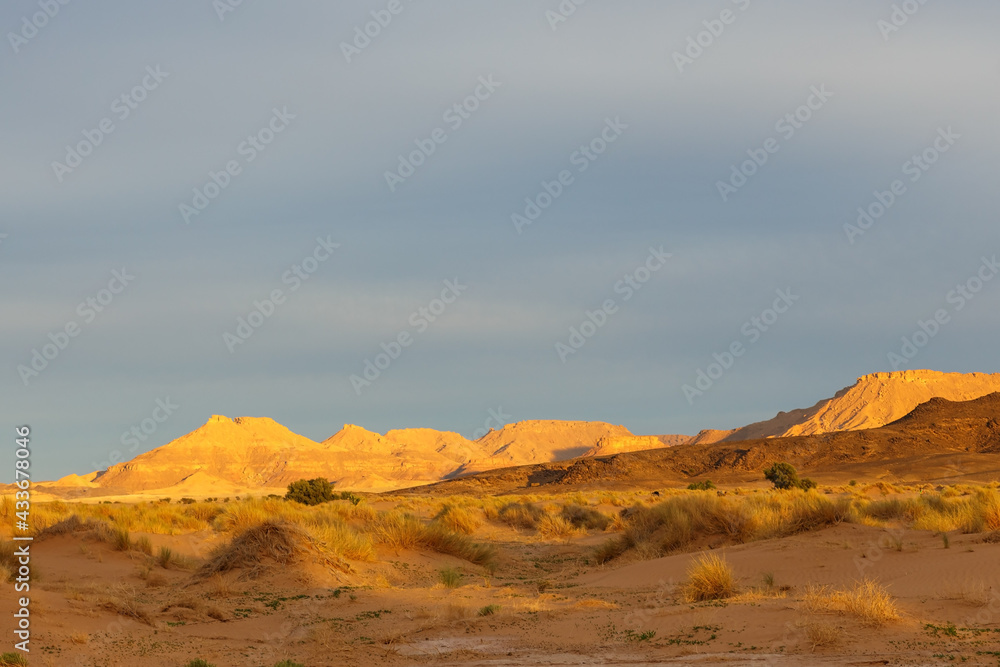Sunset in the Sahara Desert. Mountains in the rays of the setting sun. Morocco