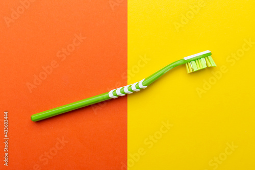 Toothbrush on a yellow-orange background. Hygiene of the oral cavity.