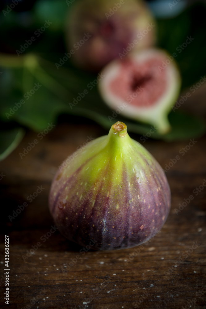 Whole fig with juicy pulp on wooden surface Whole fig with juicy pulp on wooden surface