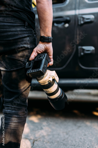 Rear view of an anonymous photographer holding his camera in the direction of his off-road car photo