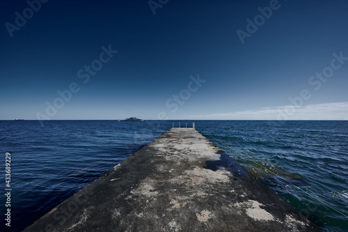 view from the pier to the yacht in the sea