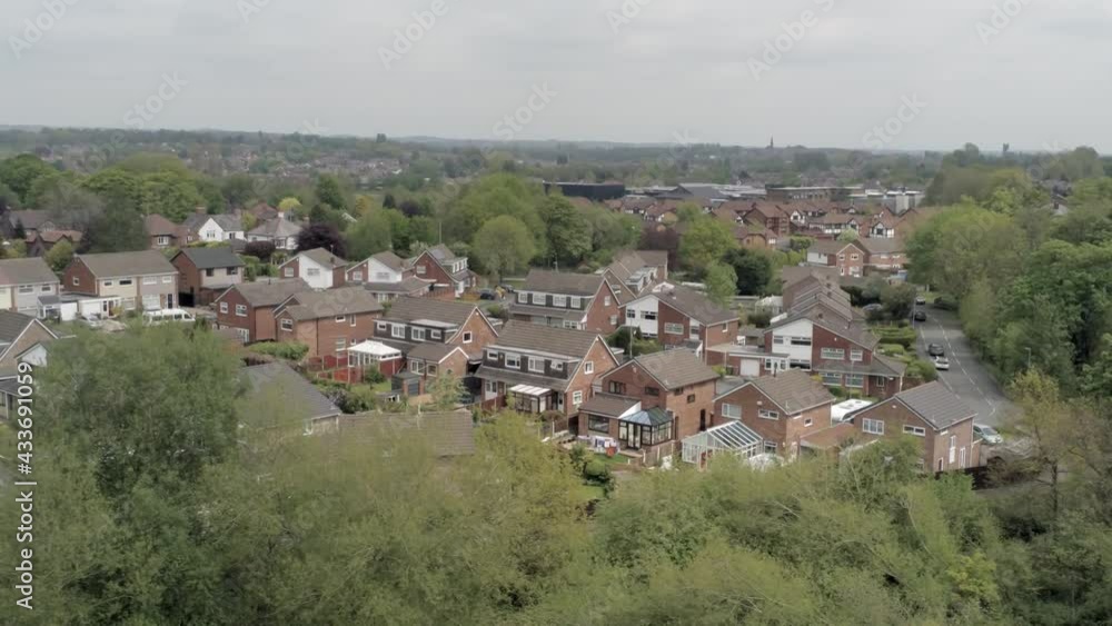 Quiet British houses and gardens residential suburban property aerial view pan right wide Quiet British houses and gardens residential suburban property aerial view pan right wide