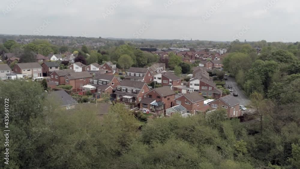 Quiet British homes and gardens residential suburban property aerial view descending tilt up over trees Quiet British homes and gardens residential suburban property aerial view descending tilt up over trees