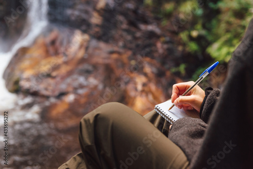 unrecognizable person taking notes in nature. hiker in the forest mountain activities. © Alberto