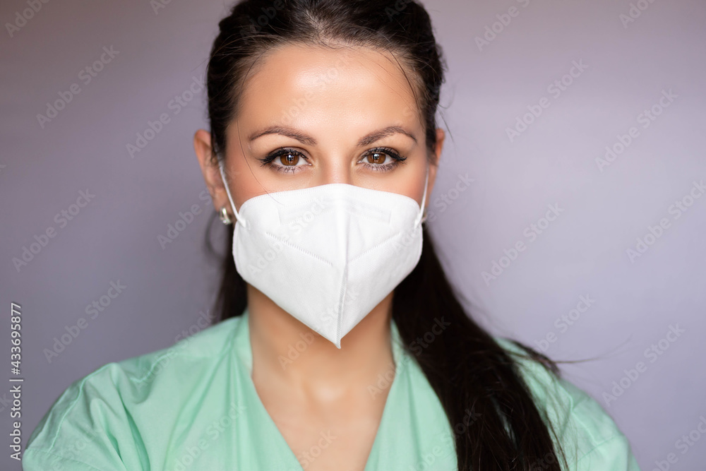 Young medical professional, nurse with protective mask. Isolated on gray Young medical professional, nurse with protective mask. Isolated on gray