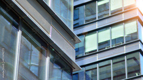 Modern architecture with sun ray. Glass and steel facade on a bright sunny day with sunbeams on the blue sky. Economy, finances, business activity concept.