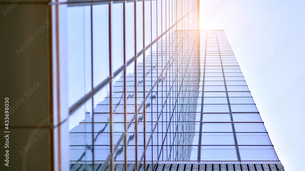 Modern architecture with sun ray. Glass and steel facade on a bright sunny day with sunbeams on the blue sky. Economy, finances, business activity concept. Modern architecture with sun ray. Glass and steel facade on a bright sunny day with sunbeams on the blue sky. Economy, finances, business activity concept.