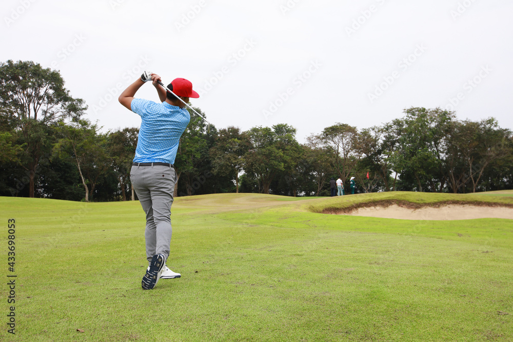 Male golf player on professional golf course. Profesioner Golfer taking a shot Male golf player on professional golf course. Profesioner Golfer taking a shot