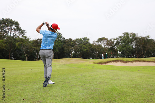 Male golf player on professional golf course. Profesioner Golfer taking a shot
