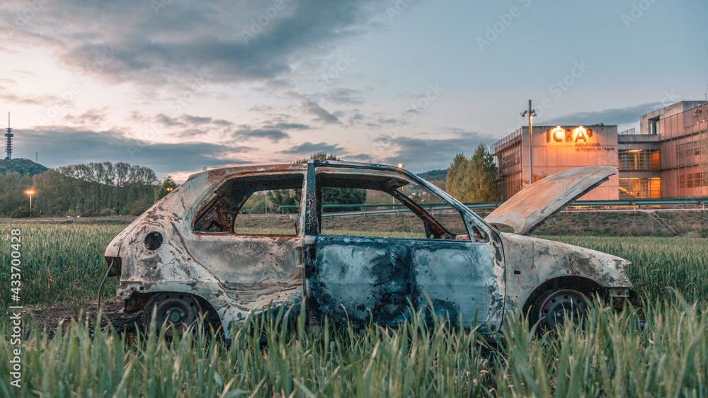 Fototapeta premium Old burnt car in the middle of a farm field
