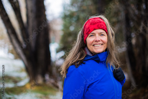 A portrait of a beautiful smiling woman outside in nature on a cold day