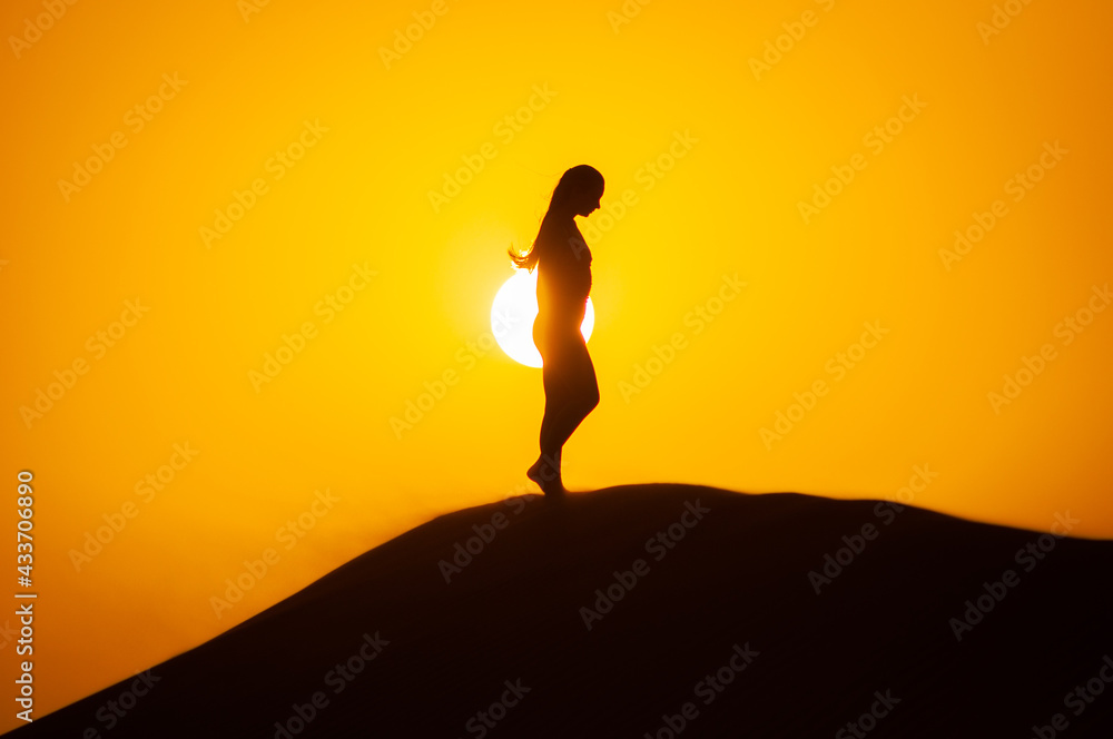 Silhouette of a young woman doing yoga pose at sunset Silhouette of a young woman doing yoga pose at sunset