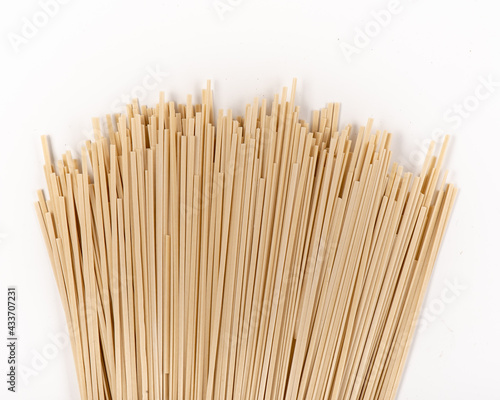 Raw whole grain spaghetti isolated on white background. Raw ramen noodles. Photo for site.