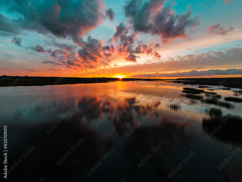 Beautiful clouds reflected on surface lake water at the sunrise. Scenic nature background