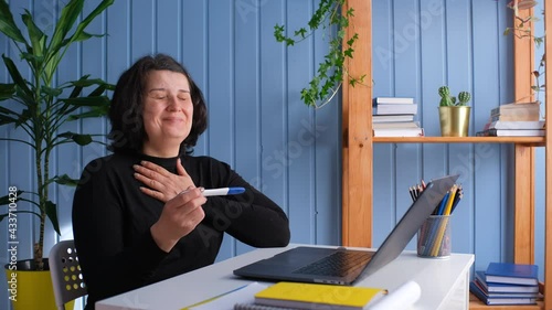Middle aged old woman looking at pregnancy test result showing positive excited for motherhood. PInfertility or IVF concept