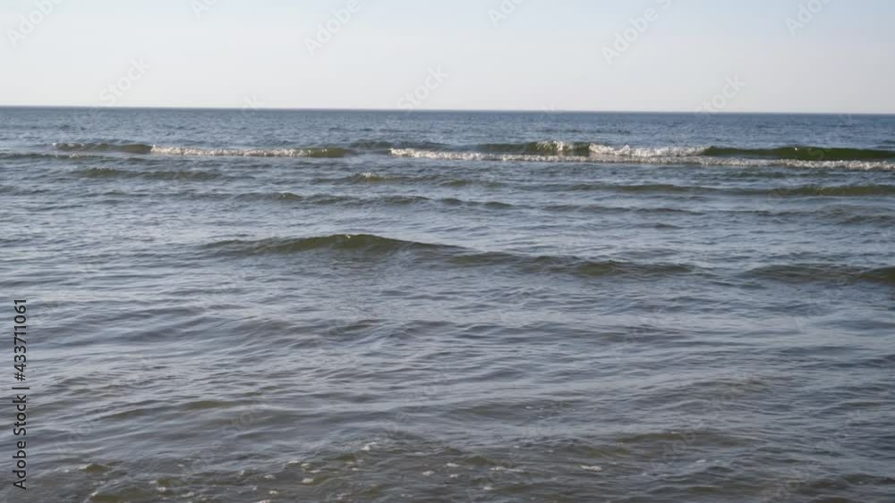 Baltic Sea, waves. Sand and green grass on the background, sunny evening, rest and relaxation concept Baltic Sea, waves. Sand and green grass on the background, sunny evening, rest and relaxation concept