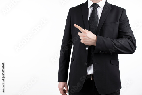 young successful businessman. Market broker man on white background, wearing suit with tie and pointing at a copy space with his finger