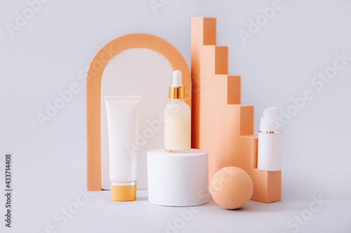 Cosmetic product presentation on geometric podiums on grey background. Beauty and body care product concept.