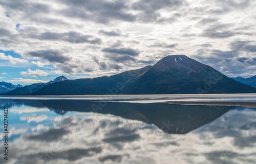 calm waters of Cook inlet near Anchorage, Alaska w/ snow capped mountains on the background.