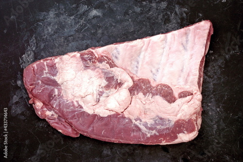 Raw Spare Ribs on Black Stone Background. Lamb or Mutton Ribs Chop Overhead View. photo