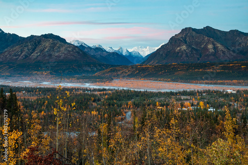 dramatic landscape of autumn foliage in the Matanuska River and snow capped mountains of the Chugach mountain range in Alaska