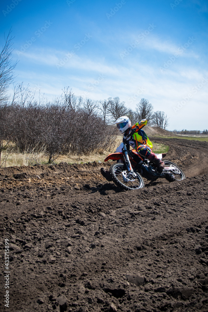 Motocross rider rides an orange dirt bike on a race track. Motocross rider rides an orange dirt bike on a race track.