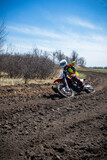 Motocross rider rides an orange dirt bike on a race track.