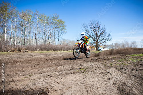 Motocross rider shoots dirt making rooster tails.