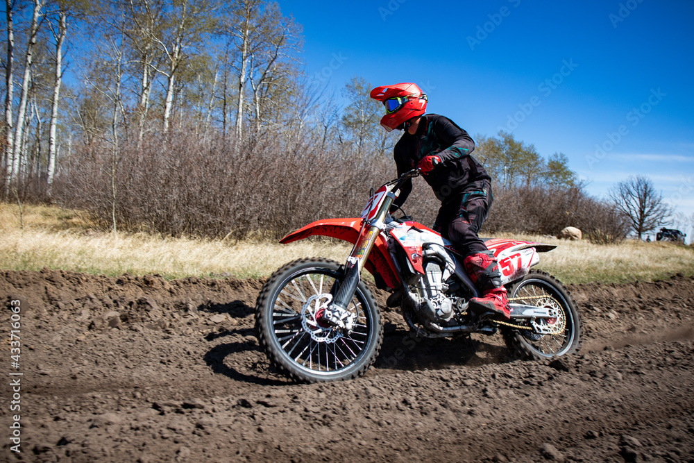 Rider looks around the corner while he races around a track. Rider looks around the corner while he races around a track.