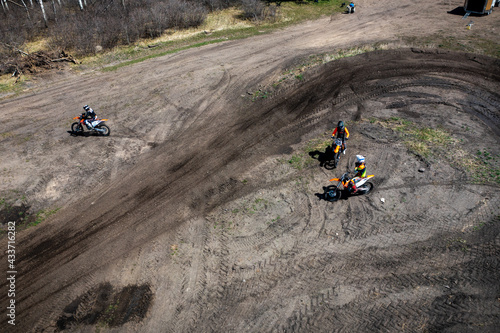 Aerial view of motocross riders on an outdoor track.