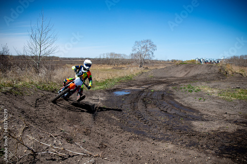 Moto X rider entering a corner. Puddle of water ont rack.