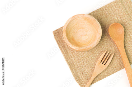 Top view of wooden cutlery utensil (fork, spoon and plate) isolated on a white background