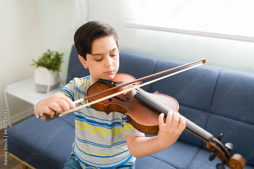 Little student practicing a song on the violin Little student practicing a song on the violin