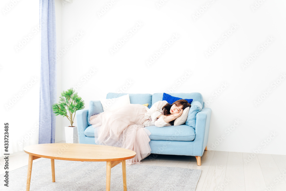 ソファーで仮眠を取る若い女性 ソファーで仮眠を取る若い女性