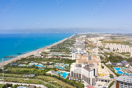 Sandy beaches of the Mediterranean. Kundu holiday complex with five star hotels. Beach, sea, water sports, parasailing, entertainment and shopping center. Aerial view with drone. Kundu, Lara -TURKEY