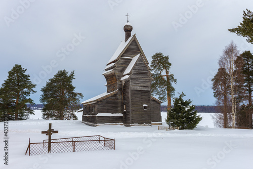 View of the old wooden church of St. George the Victorious (1522) on a gloomy February day. Rodionovo (Yuksovichi). Leningrad region, Russia photo