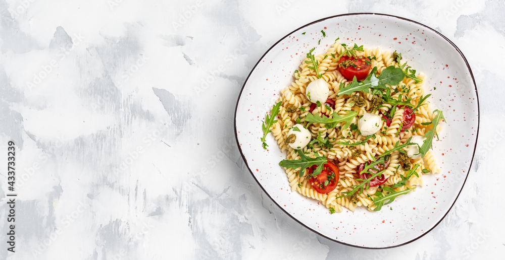 vegetarian salad, vegetable pasta Caprese salad with cherry tomatoes and mozzarella cheese. Long banner format, top view vegetarian salad, vegetable pasta Caprese salad with cherry tomatoes and mozzarella cheese. Long banner format, top view