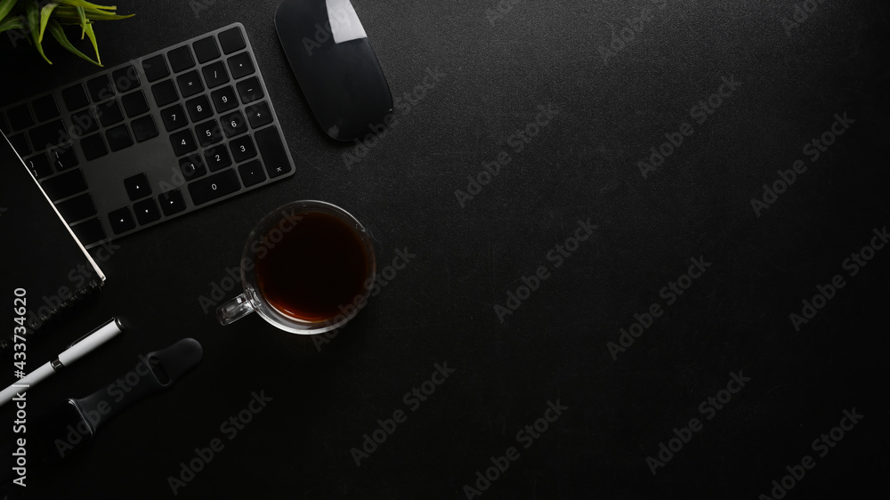 Fototapeta Nowoczesna, ciemna przestrzeń do pracy z czarnym wyposażeniem i miejscem na kopię na czarnej skórze.