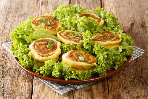 French snail food is a roll of ground beef and egg noodles close-up in a plate on the table. horizontal