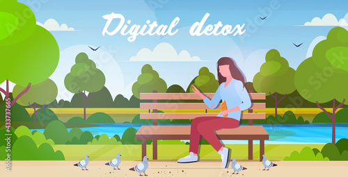 woman feeding flock of pigeons in park spending time without devices digital detox concept