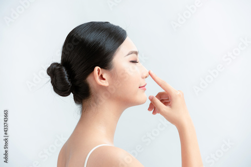 beauty skincare woman smile happily and pointing her nose on white background photo