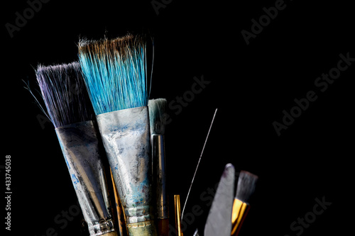 Several art brushes and spatulas of different sizes on a black background. Copy space. photo