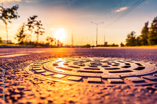 Sunset in the country, the empty highway. Wide angle view of the level of a manhole on the pavement photo