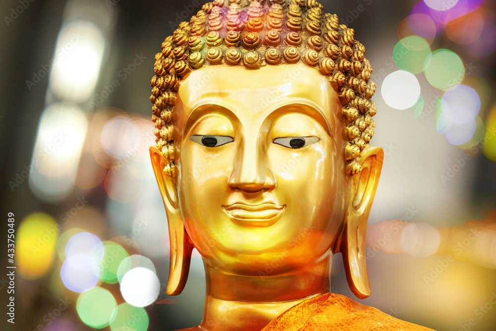 Golden Buddha face image on yellow background.