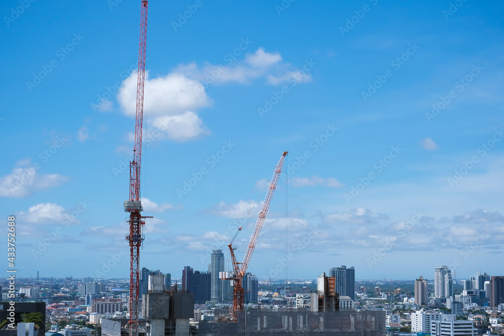 Building construction with crane against blue sky background,  Steel frame structure,