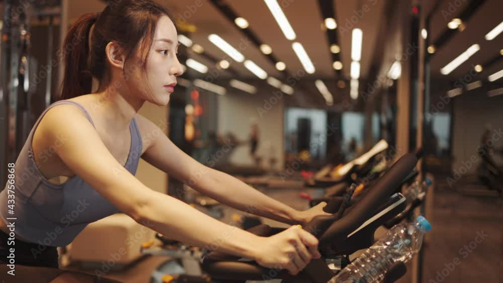 Young beautiful woman asian running on a treadmill at gym. Fitness and healthy lifestyle concept. Side view of girl in sportswear jogging exercise. Young beautiful woman asian running on a treadmill at gym. Fitness and healthy lifestyle concept. Side view of girl in sportswear jogging exercise.