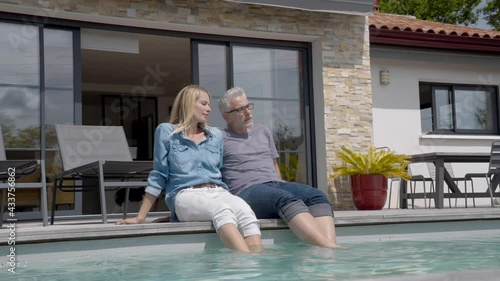 Middle-aged couple enjoying time by private pool