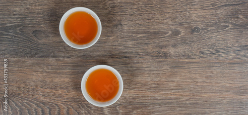 two white small tea bowls on wooden table, above panoramic shot